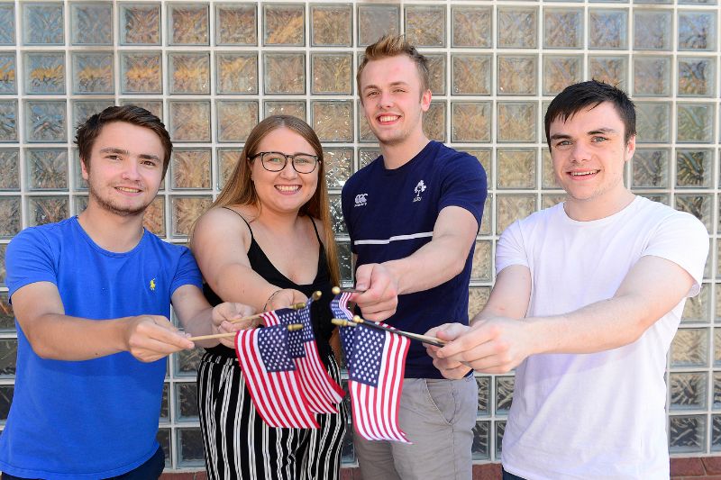 students standing holding small American flags